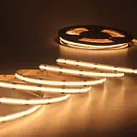 Warm white LED strip light unrolled, glowing brightly.