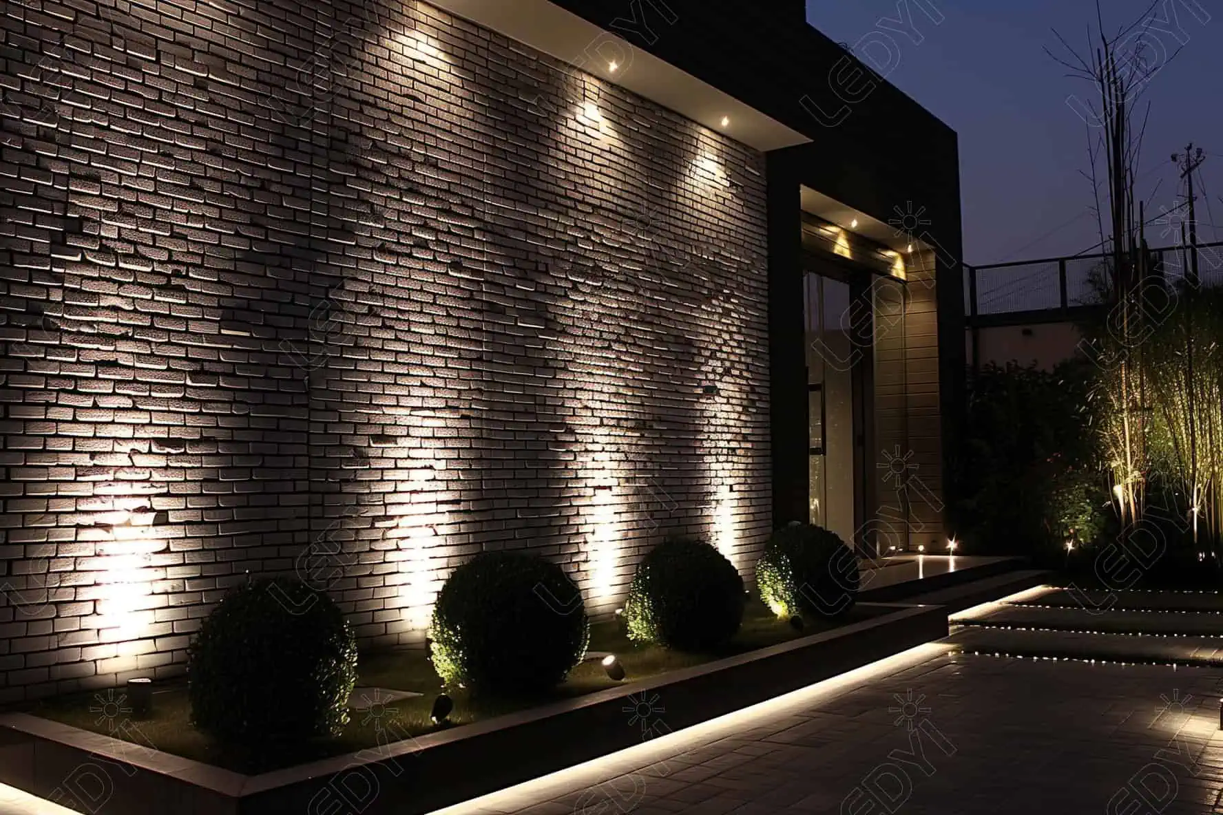 Jardim noturno com iluminação de parede moderna.