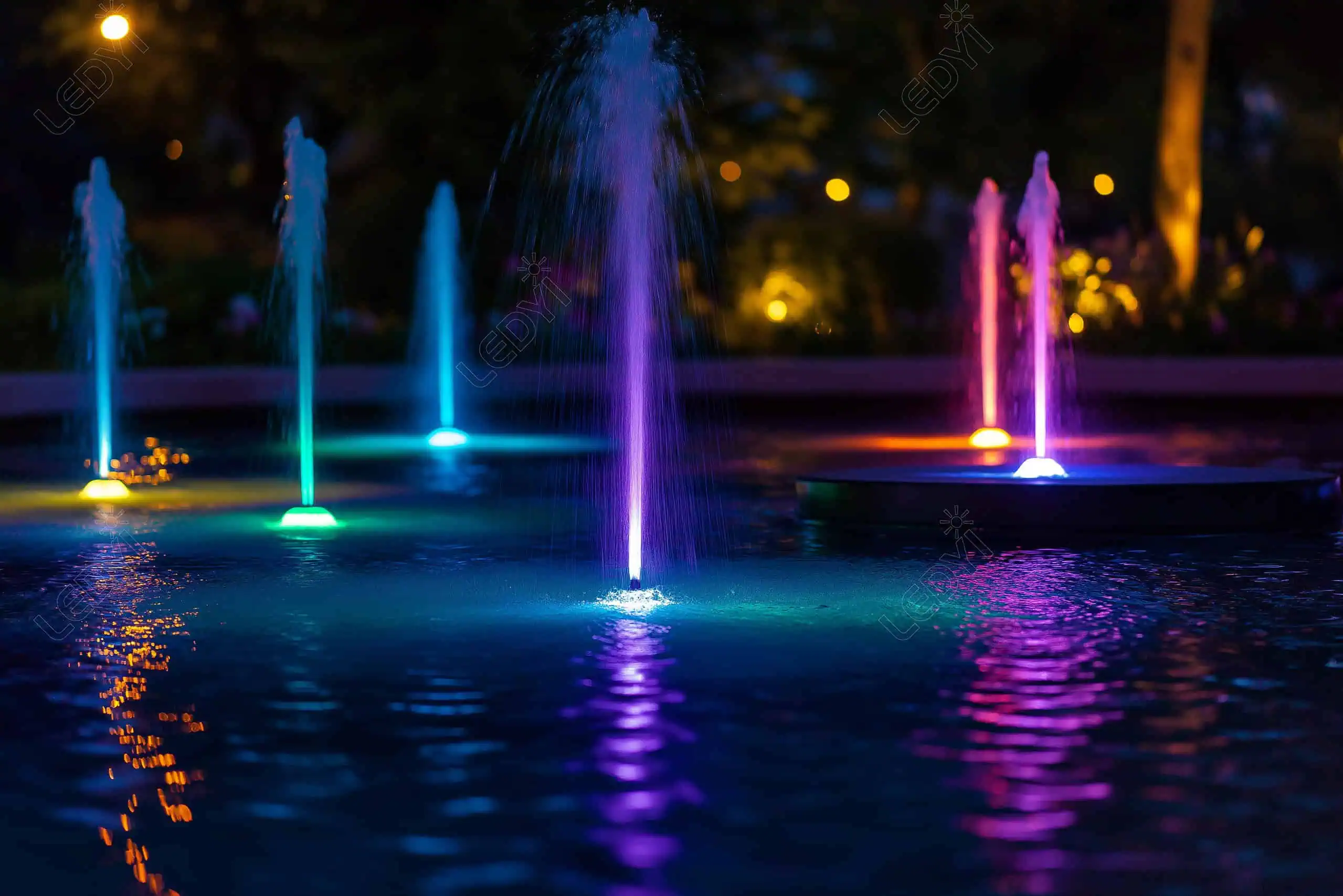 Colorful illuminated water fountains at night.