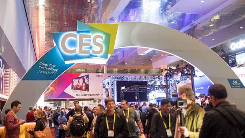 Crowd at CES technology expo entrance arch.